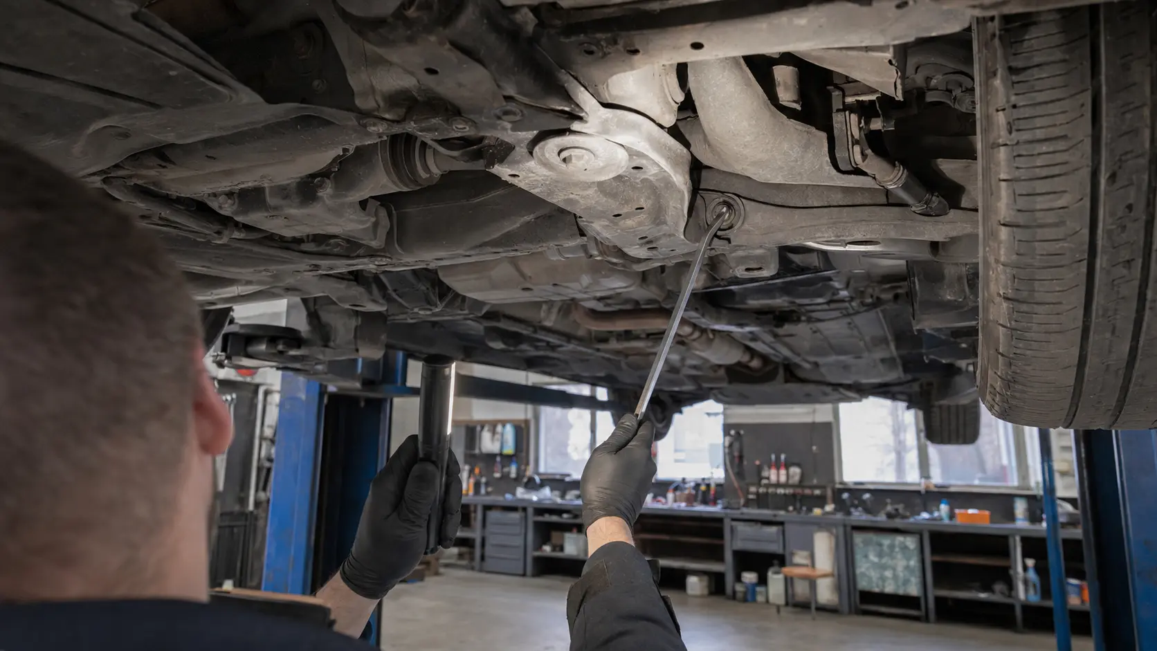Mehaanik kontrollib tõstukil oleva sõiduauto veermikku ja põhja